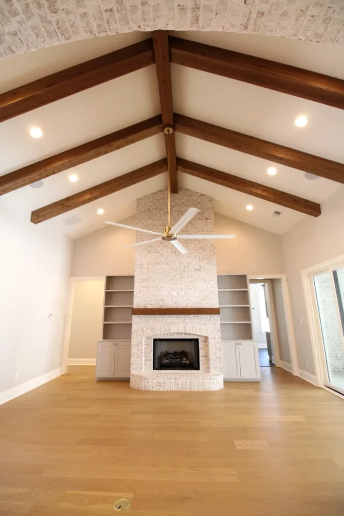 A luxury home addition featuring a screened pool enclosure with a built-in spa, travertine paver patio, covered outdoor kitchen area with ceiling fans, and a second-floor balcony overlooking the pool. A stunning Philadelphia home addition that maximizes outdoor living and entertainment space.